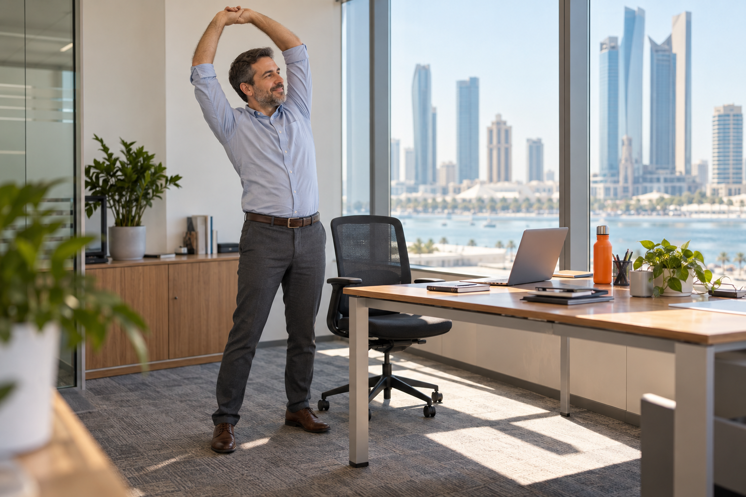 Office worker stretching beside his desk during a movement break.